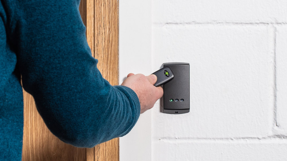 Man using key fob access control to enter building securely